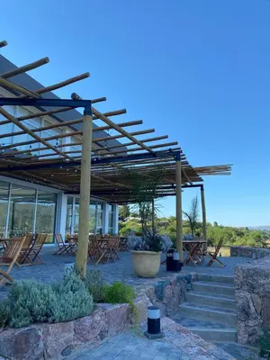 a patio with a wooden pergola and chairs at Veneto Village Resort & Spa in Villa Carlos Paz