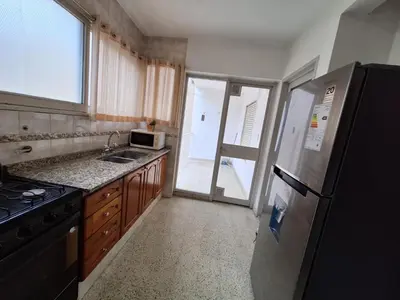 a kitchen with a refrigerator and a sink and a window at Depto Carlos I in Villa Carlos Paz