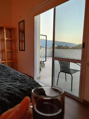 a person holding a glass of wine in front of a door at TERRAZA TERRAZA Merlo Apartments in Merlo