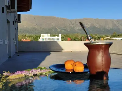 a vase and two plates of oranges on a table at TERRAZA TERRAZA Merlo Apartments in Merlo