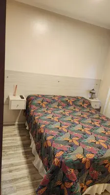 a bed with a colorful comforter in a room at Depto Elba centro opcion cochera in Cordoba