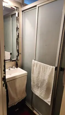 a bathroom with a sink and a shower with a mirror at Depto Elba centro opcion cochera in Cordoba