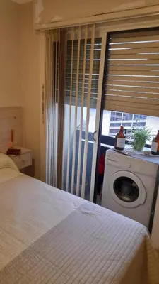 a bedroom with a washing machine and a window at Depto Elba centro opcion cochera in Cordoba
