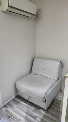 a white couch in a corner of a room at Depto Elba centro opcion cochera in Cordoba