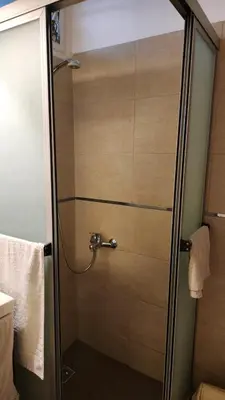a shower with a glass door in a bathroom at Depto Elba centro opcion cochera in Cordoba