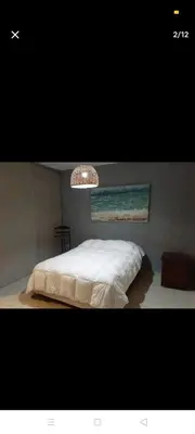 a bedroom with a white bed and a chandelier at Excelente casa, Ideal para Familia Fines de Semana in Cordoba