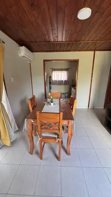 a dining room with a wooden table and chairs at Cabañas cata 1 in Villa Santa Cruz del Lago