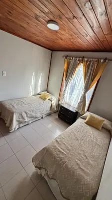 a bedroom with two beds and a wooden ceiling at Cabañas cata 1 in Villa Santa Cruz del Lago