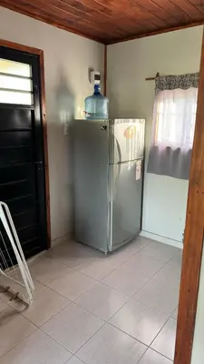 a kitchen with a refrigerator with a bottle on top of it at Cabañas cata 1 in Villa Santa Cruz del Lago