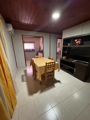 a dining room with a table and a television at Cabañas cata 1 in Villa Santa Cruz del Lago