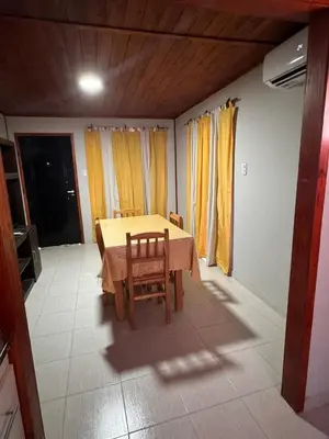 a table and chairs in a room with yellow curtains at Cabañas cata 1 in Villa Santa Cruz del Lago