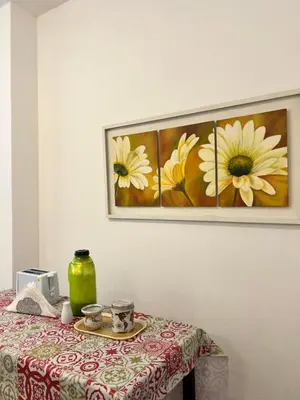 a table with a flower painting on the wall at Bello Departamento PB en mejor zona de nva cba atencion personalizada in Cordoba