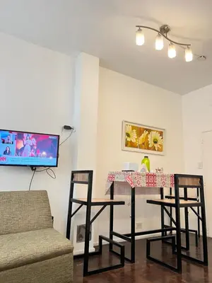 a living room with a table with chairs and a tv at Bello Departamento PB en mejor zona de nva cba atencion personalizada in Cordoba