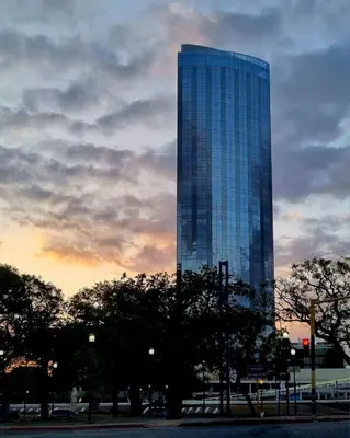 a tall glass building with trees in front of it at Moderno departamento/Loft Córdoba - Coral State in Cordoba