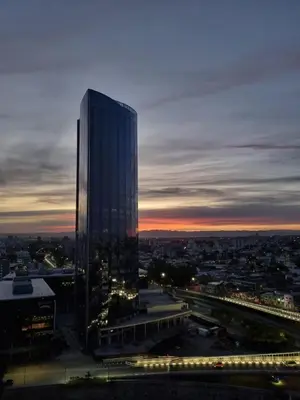a tall building with lights in front of a city at Moderno departamento/Loft Córdoba - Coral State in Cordoba