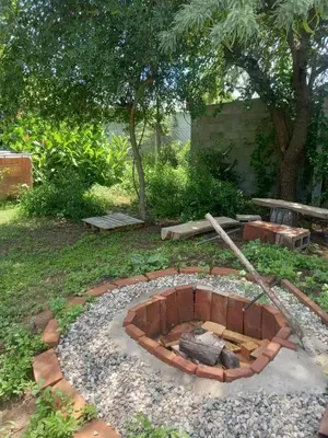 a fire pit in a garden with rocks and trees at EcoCasa in Cordoba