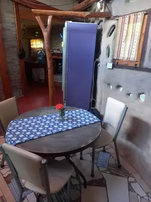a table and chairs in a room with a refrigerator at EcoCasa in Cordoba
