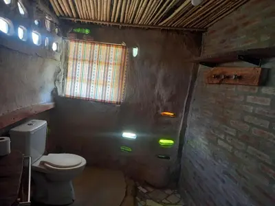 a bathroom with a toilet and a brick wall at EcoCasa in Cordoba