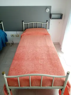 a bed with an orange blanket on it in a room at Kempes, Ferial Chateau in Cordoba