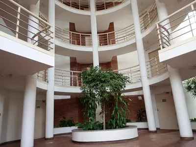 a large building with white columns and plants at Kempes, Ferial Chateau in Cordoba