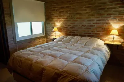 a bedroom with a large bed with a brick wall at Santa Mate in Nono