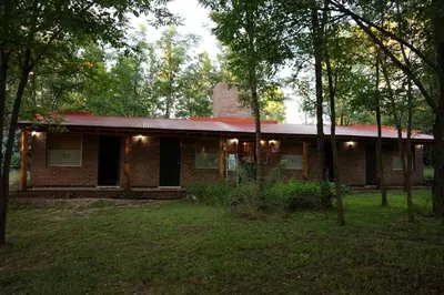 a brick house with a red roof in the woods at Santa Mate in Nono