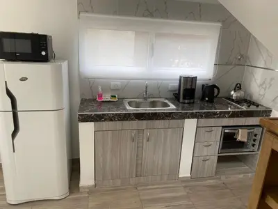 a kitchen with a white refrigerator and a sink at cuatro vientos 1 in Santa Rosa de Calamuchita