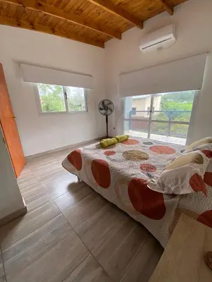 a bedroom with a bed and a large window at cuatro vientos 1 in Santa Rosa de Calamuchita