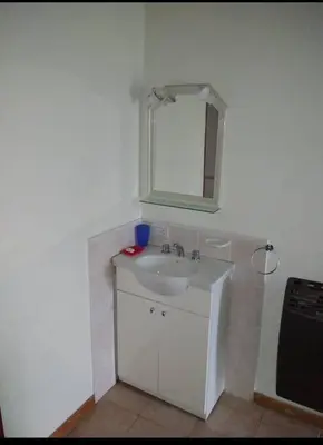 a white bathroom with a sink and a mirror at Santa Julia in Villa General Belgrano