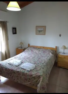 a bedroom with a bed and two night stands with lamps at Santa Julia in Villa General Belgrano