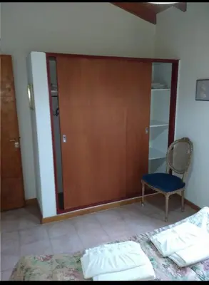 a room with a wooden door and a chair and a bed at Santa Julia in Villa General Belgrano
