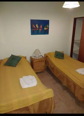 a room with two beds and a painting on the wall at Santa Julia in Villa General Belgrano