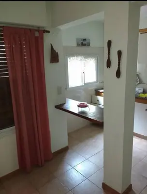 a kitchen with a red curtain and a window at Santa Julia in Villa General Belgrano