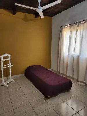 a bed in a room with a ceiling fan and a window at La Vivi in Villa Larca
