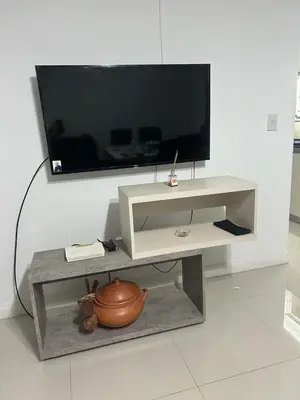 a white entertainment center with a large television on a wall at Bienamada in Merlo