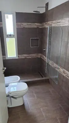 a bathroom with a toilet and a glass shower at Bienamada in Merlo