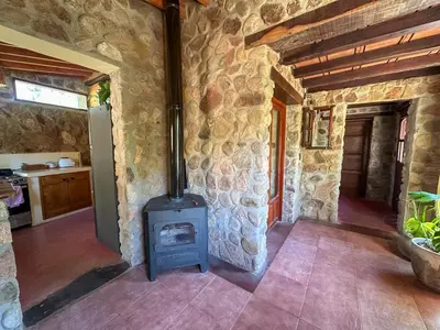 a stone kitchen with a stove in a room at Casa de piedra con jardin y pileta - privada in Los Hornillos