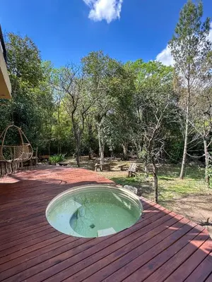 a small pool on top of a wooden deck at Casa de piedra con jardin y pileta - privada in Los Hornillos
