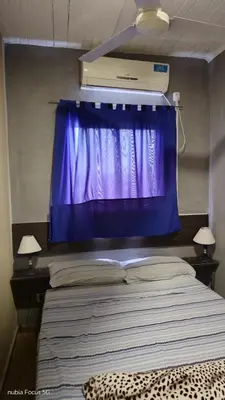 a bedroom with a purple curtain and a bed at Lo de Andrés y Marina in Arroyo de Los Patos