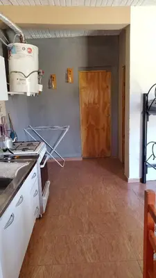 a kitchen with a counter and a door to a room at Lo de Andrés y Marina in Arroyo de Los Patos