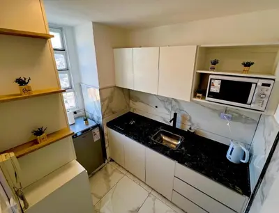 a small kitchen with a sink and a microwave at DEPARTAMENTO CENTRAL in Cordoba