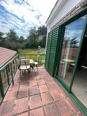a patio with a table and a bench on a balcony at Petit House in Villa Carlos Paz