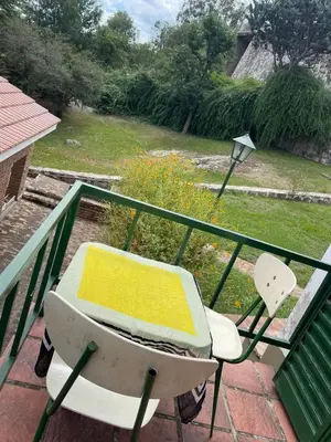 a table and a chair on a balcony with at Petit House in Villa Carlos Paz
