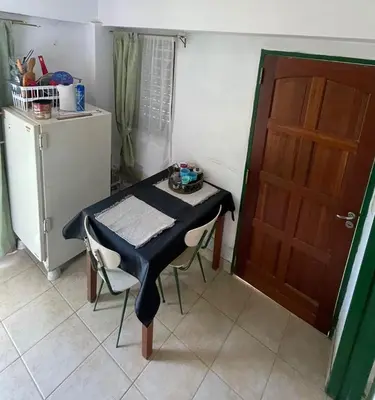 a table and chairs in a kitchen with a door at Petit House in Villa Carlos Paz