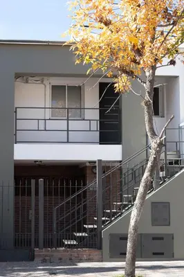 a building with a tree in front of it at Punto Golondrina in Alta Gracia