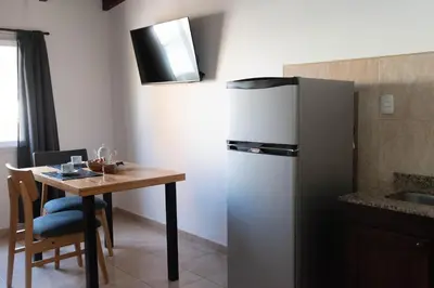 a kitchen with a small table and a refrigerator at Punto Golondrina in Alta Gracia