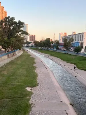 a river in the middle of a city with buildings at Departamento del Río - Late CheckOut in Cordoba