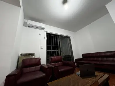 a living room with a couch and chairs and a laptop at Departamento del Río - Late CheckOut in Cordoba
