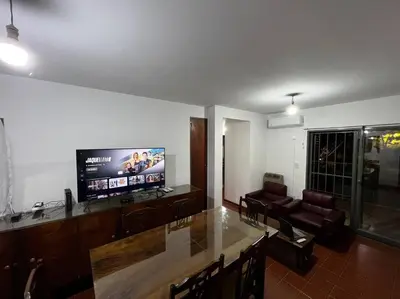 a living room with a tv and a table and chairs at Departamento del Río - Late CheckOut in Cordoba