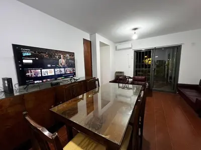 a dining room with a glass table and a television at Departamento del Río - Late CheckOut in Cordoba
